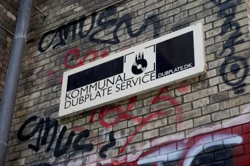 An image of Kommunal Dubplate Service's logo over their building entrance.