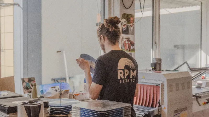 Image of company CEO Gudmundur visually inspecting a record.