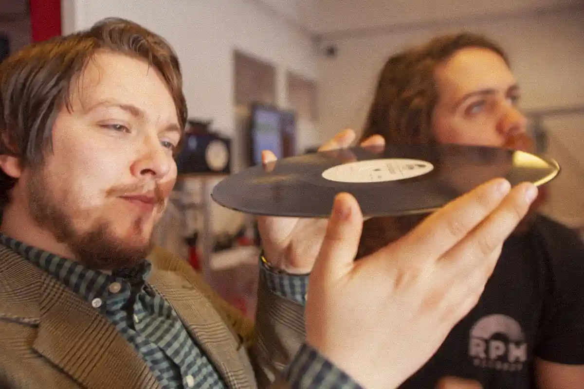 Image of company CEO Gudmundur visually inspecting a record.